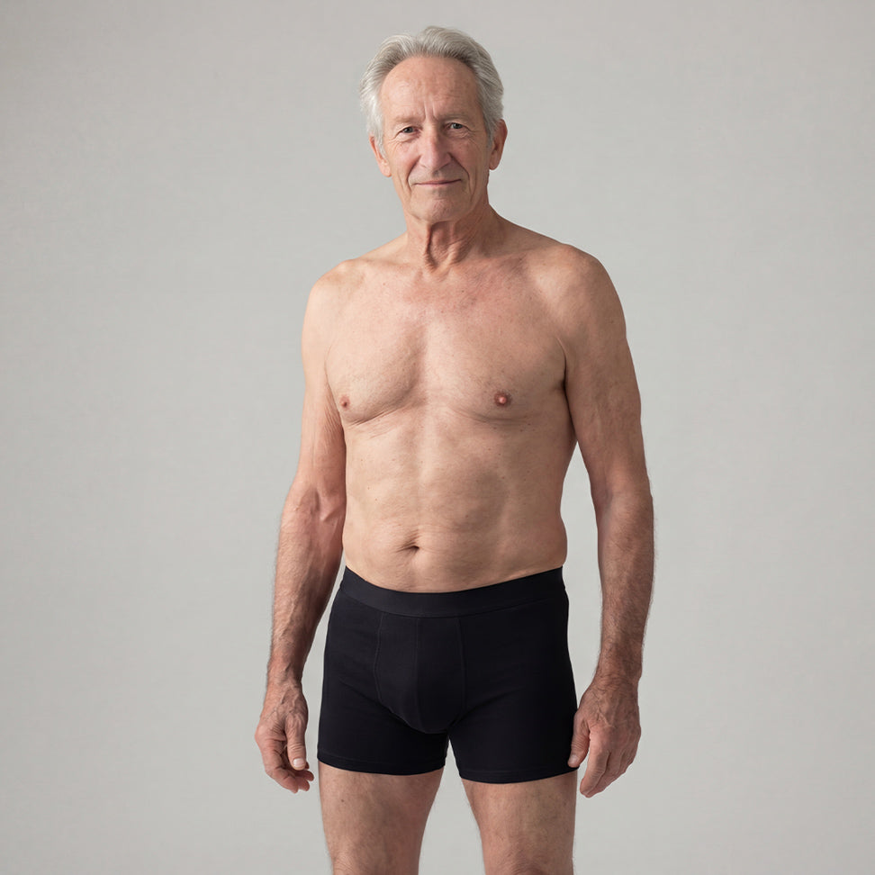 Homme senior portant un boxer absorbant noir pour fuites urinaires légères, sous-vêtement discret et confortable, protection lavable et réutilisable pour incontinence masculine légère, design ajusté et respirant pour un usage quotidien.