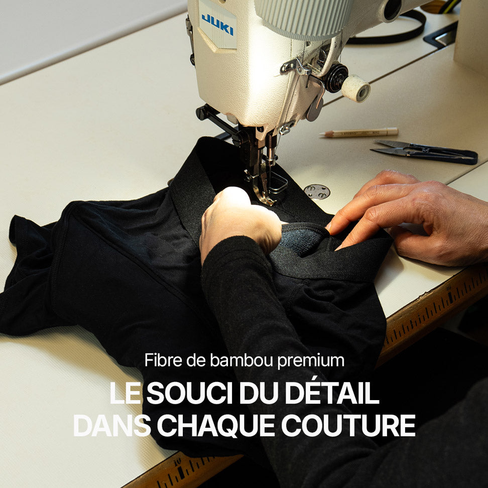 Atelier de confection montrant une machine à coudre en train d’assembler un boxer noir Orykas en fibre de bambou premium, focus sur la précision des coutures et le souci du détail dans la fabrication.
