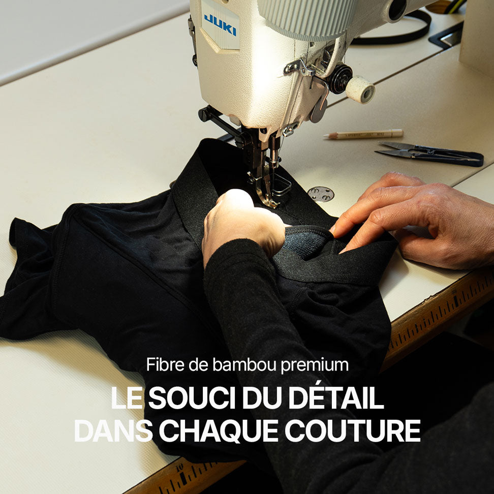 Atelier de confection avec machine à coudre industrielle en train de travailler un boxer absorbant noir, mise en avant de la fibre de bambou premium et du soin apporté à chaque couture, illustrant la qualité de fabrication et le souci du détail pour un sous-vêtement lavable conçu contre les fuites urinaires.